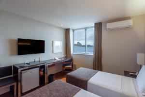 里约热内卢奥拉克帕卡巴那酒店的酒店客房配有一张床和一张书桌及一台电视