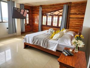卡约港Hostal Poseidon的一间卧室设有一张带木墙的大床