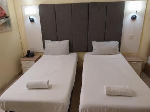 SalinaWhitestar Guesthouse的配有2张床的带白色床单和枕头的客房