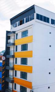 佩雷拉Hotel Dibeni Pereira的公寓大楼拥有黄色和白色