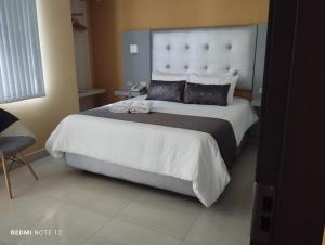 佩雷拉Hotel Dibeni Pereira的一间卧室配有一张大床和大床头板