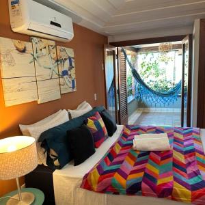 布希奥斯Casa de CINEMA 3 suites, 50m da Praia da Ferradura的一间卧室配有一张带彩色毯子的床