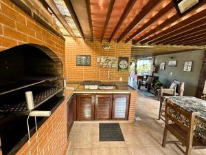 布希奥斯Casa de CINEMA 3 suites, 50m da Praia da Ferradura的厨房设有砖墙和烤箱