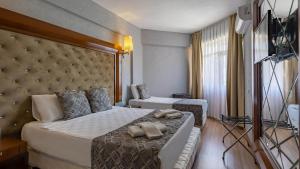 安塔利亚Lara Olympos Hotel的酒店客房带一张大床和一把椅子
