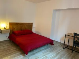沙布利Le Cristallin gîte plein coeur de Chablis的一间卧室配有一张红色的床和木制床头板
