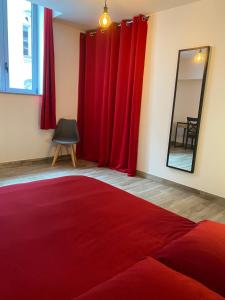 沙布利Le Cristallin gîte plein coeur de Chablis的一间设有红色窗帘、镜子和红色地毯的房间
