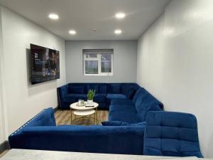 伯明翰Stunning Studio in Birmingham的客厅配有蓝色的沙发和桌子