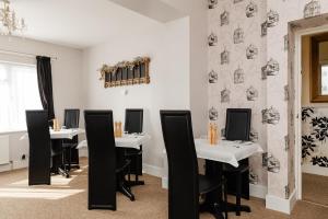 桑当贝尔旅馆 的用餐室配有白色桌子和黑色椅子