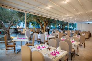 哈马马特Le Hammamet Hotel & SPA的宴会厅配有桌椅和树木