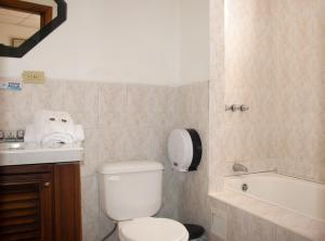 普约Hotel Colonial的浴室配有卫生间、盥洗盆和浴缸。
