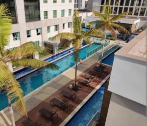 巴西利亚Jade Hotel BLUE Tree Brasília Flat Particular wi-fi e garagem grátis sem café的享有酒店游泳池的顶部景色,游泳池种植了棕榈树