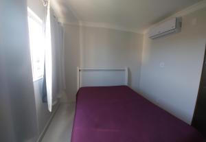 维拉维尔哈apartamento para até 5 pessoas的一间小卧室,配有紫色的床和窗户