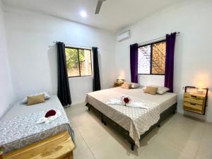 MéridaVilla Ometepe的一间卧室设有两张床和两个窗户。