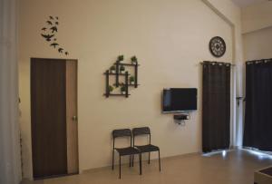 卡尔贾特Mountainview Paradise的一间设有两把椅子、一台电视和一面墙的房间