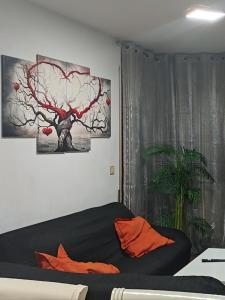 博尔塔纳Alojamiento Tierra del Ara的一间卧室配有黑色床、橙色枕头和一棵树。