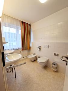 柏林凯塞酒店的一间带两个盥洗盆、卫生间和窗户的浴室