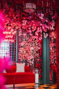 新奥尔良Virgin Hotels New Orleans的一间红色沙发的房间,墙上有鲜花