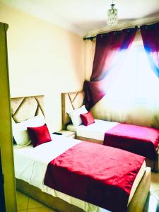 阿加迪尔Appartement luxueux Centre Agadir的红色和白色的客房内的两张床
