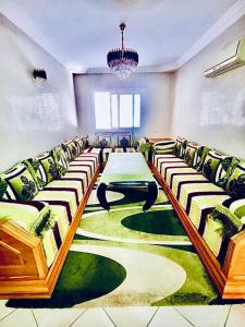 阿加迪尔Appartement luxueux Centre Agadir的一间会议室,在绿色地毯上配有桌椅