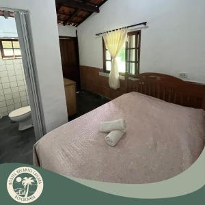 圣塞巴斯蒂安Hostel Recanto Caiçara的一间卧室配有一张床,上面有两条毛巾