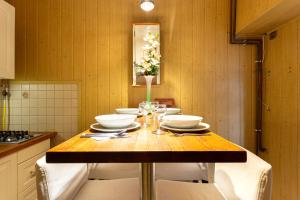 布达佩斯Rivercity South Buda Hills的厨房配有带白色碗的木桌