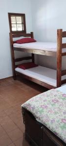 圣塞巴斯蒂安Hostel Recanto Caiçara的客房设有两张双层床和一扇窗户。