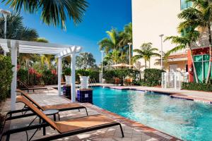 霍姆斯泰德迈阿密家园万怡酒店的毗邻度假酒店的带躺椅的游泳池