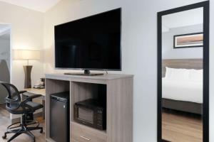 爱达荷福尔斯Quality Inn Idaho Falls的酒店客房设有电视和床。
