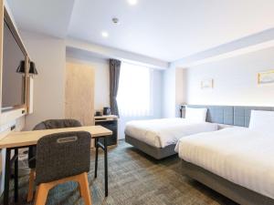 名古屋Comfort Hotel Nagoya Shinkansenguchi的酒店客房配有两张床和一张书桌