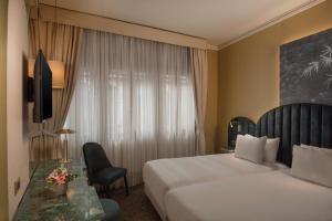 威尼斯NH Venezia Santa Lucia的一间设有大床和窗户的酒店客房