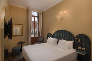 威尼斯NH Venezia Santa Lucia的卧室设有一张白色大床和一扇窗户。
