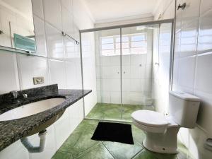 坎波斯杜若尔当Quatro Estacoes Hospeda -Vila 01 , sua casa em Campos do Jordao, a 1 km do centro turistico的浴室配有卫生间、盥洗盆和淋浴。