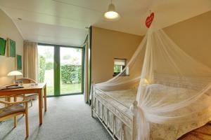 尼斯泰兹小屋乡村别墅的一间卧室配有一张带蚊帐的床