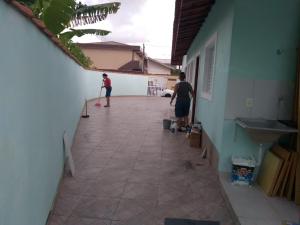 瓜鲁柳斯casa na praia Itanhaém的两个人在走廊上玩滑板