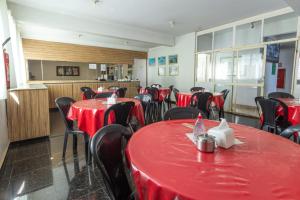 戈亚尼亚Hotel Terra Cedro In的用餐室配有红色桌子和黑色椅子