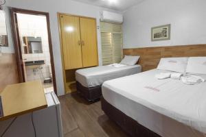 戈亚尼亚Hotel Terra Cedro In的酒店客房带两张床和一间浴室
