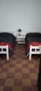 拉库布蕾HOTEL PARAISO的一间卧室设有两张床,铺有一个 ⁇ 板地板