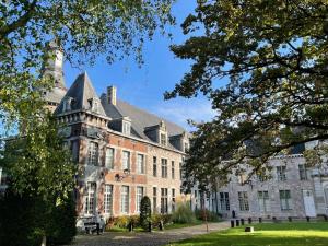 Fontaine-lʼÉvêqueAppartement 6 personnes Hotel Ferme Du Château Fontaine的一座带塔楼的大型砖砌建筑