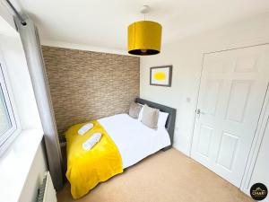 KentonModern 3 Bedroom House With FREE Parking的一间卧室配有一张黄色毯子床