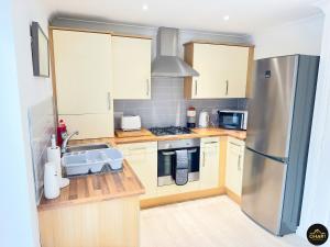 KentonModern 3 Bedroom House With FREE Parking的厨房配有木制柜台和不锈钢冰箱。