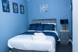 特尔福德Lush Lodge -Home away in Telford的蓝色卧室,配有蓝色墙壁的床
