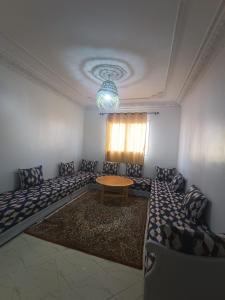 瓦尔扎扎特Appartement Sariq Ouarzazate的一间客房内配有桌椅的房间