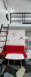 邦美蜀SKY HOMESTAY的一张高架床,在房间内配有红色沙发