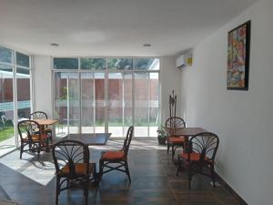 坎昆Villas Carlota Cancún的用餐室设有桌椅和窗户。