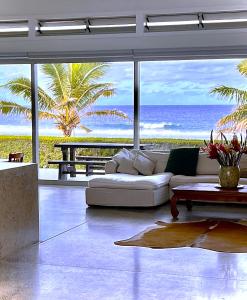 拉罗汤加Coast Cook Islands的客厅配有白色沙发,享有海景