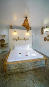 爱妮岛Serenity Hotel的一间卧室配有一张带白色床单的大床