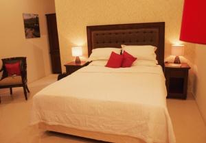 哲帕拉格科乡村旅馆的卧室配有带红色枕头的大型白色床