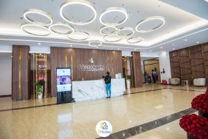 河内Royal Serviced apartment Vinhomes Metropolis的站在大楼前厅的人