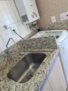 卡庞达卡诺阿Apartamento Beira mar Capão da Canoa的厨房柜台设有水槽和洗衣机。