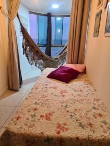 卡庞达卡诺阿Apartamento Beira mar Capão da Canoa的一张位于带吊床的客房内的床铺